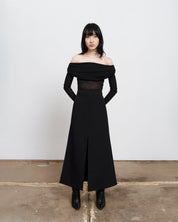 Full body image of The Ada Top, a Black semi sheer, rouched off the shoulder top on women with dark hair and hands gently placed behind her back 